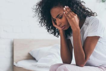 woman holding hands near head while suffering from headache in bedroom | Image Credit: LIGHTFIELD STUDIOS - stock.adobe.com