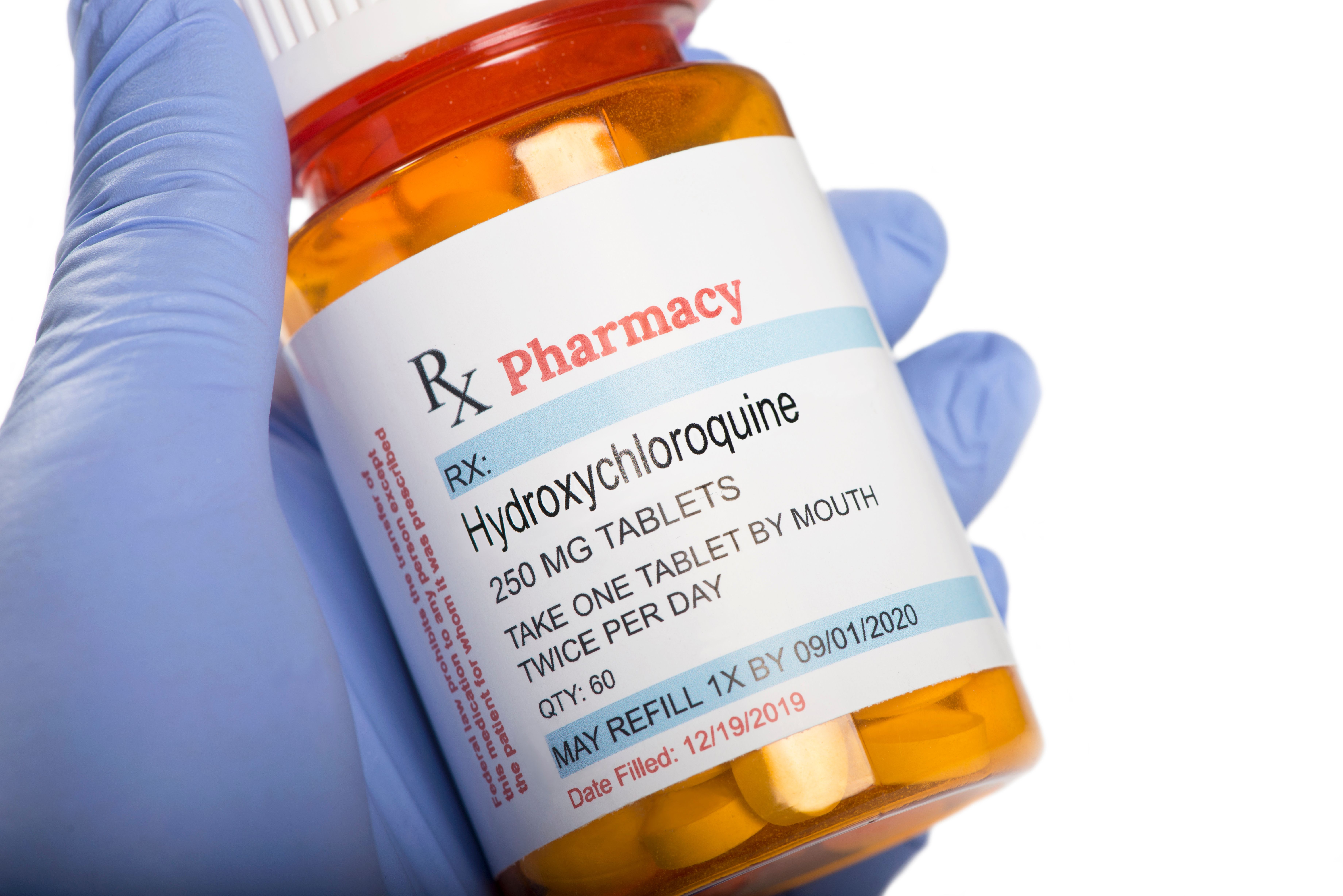 Pharmacist holding prescription bottle of hydroxychloroquine | Image Credit: © Sherry Young - stock.adobe.com