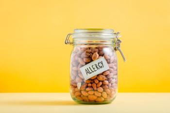 Glass jar full of peanuts with 'Allergy' sign in it. Food allergy and health concept - Image credit: Marina | stock.adobe.com