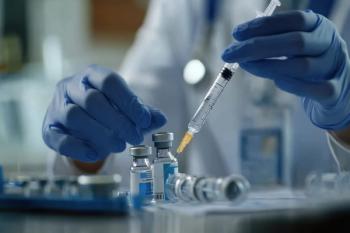 Close-up of a doctor in gloves filling a syringe with vaccine from vials, set in a clinical lab environment. | Image Credit: Nikita Starodubtsev | stock.adobe.com