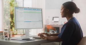 Portrait of a Black Female Medical Health Care Professional Working on Desktop Computer in Hospital Office. Clinic Head Nurse is Appointing Prescriptions Online, Updating Electronic Health Records