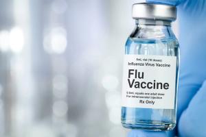 Healthcare concept with a hand in blue medical gloves holding Flu, Influenza, vaccine vial - Image credit: Leigh Prather | stock.adobe.com