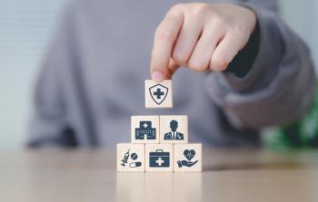Health insurance and medical care concept. Woman placing wooden blocks with health-related icons, medical care, health insurance, and medication. healthcare services, protection, insurance coverage- Image credit: Sandwish |stock.adobe.com