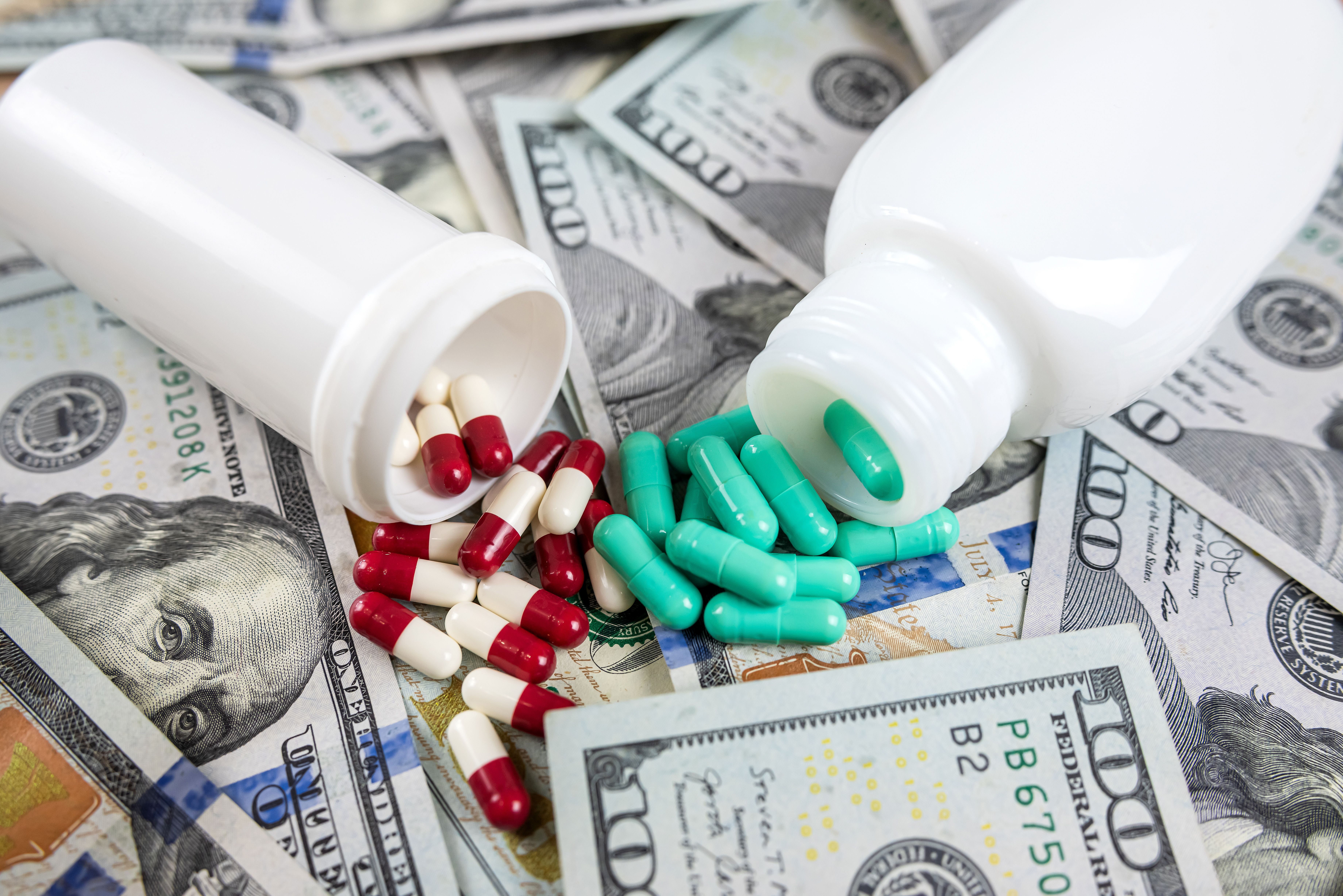 Pills spilled on United States dollars | Image Credit: © RomanR - stock.adobe.com