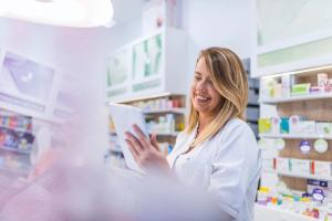 Pharmacist working with a tablet computer in the pharmacy holding it in her hand while reading information | Image Credit: Dragana Gordic - stock.adobe.com