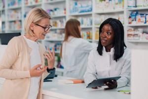 Pharmacist and patient in a retail/community pharmacy setting -- Image credit: Zamrznuti tonovi | stock.adobe.com