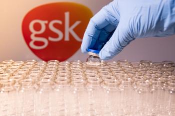 Scientist holding the glass vial, GSK blurred in background | Image Credit: © desertsands - stock.adobe.com
