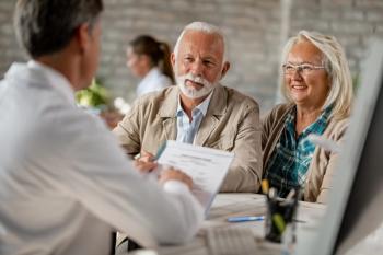 Happy senior couple going through medical insurance paperwork with a doctor - Image credit: Drazen | stock.adobe.com