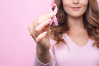 Woman holding pink breast cancer awareness ribbon -- Image credit: marina_li_1 | stock.adobe.com