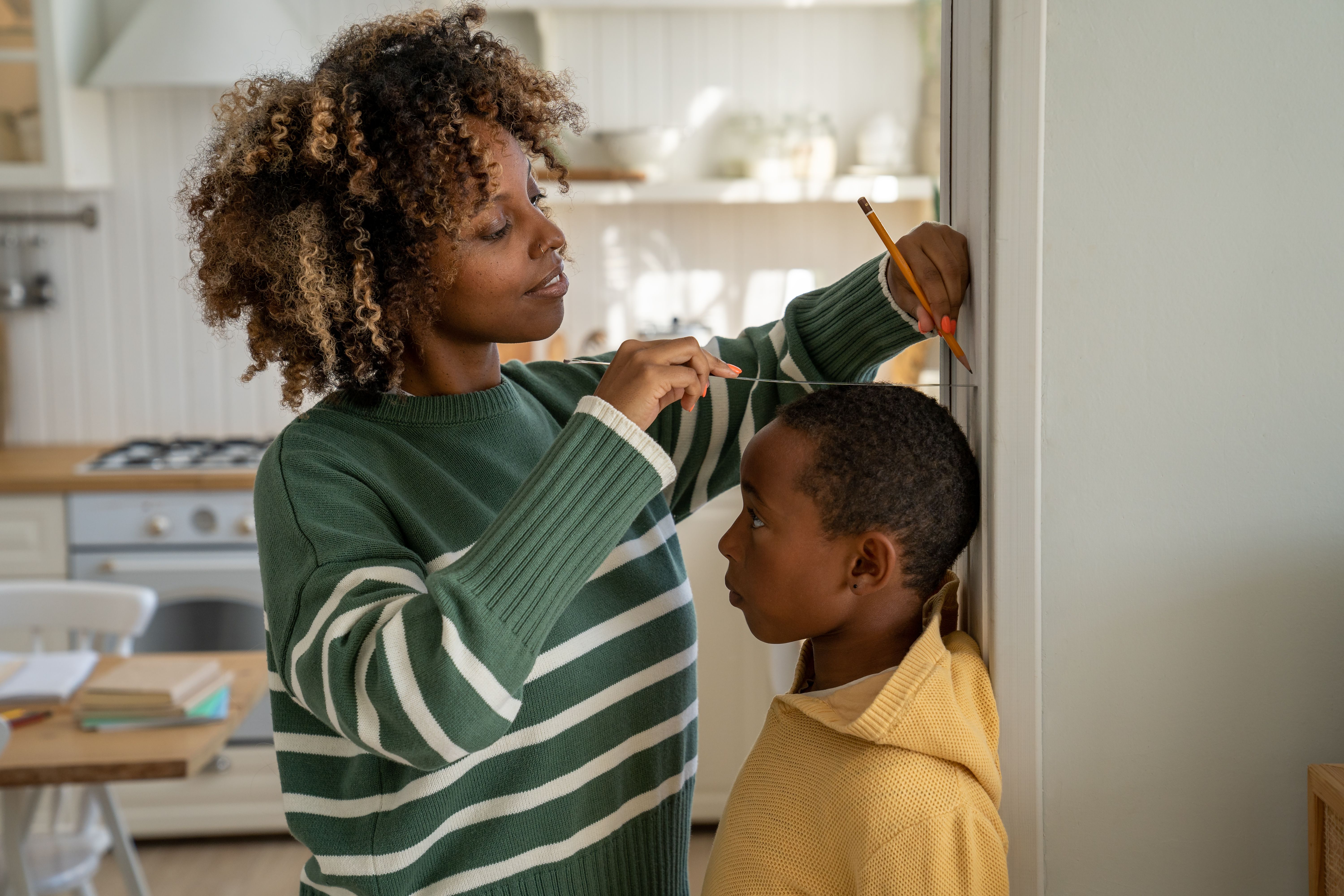 Young child having his height measured by his mother -- Image credit: DimaBerlin | stock.adobe.com