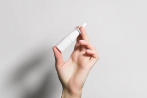 hand holding a white bottle with nasal spray | Image Credit: Iryna_B | stock.adobe.com