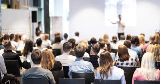 Conference attendees watching a speaker | Image credit: kasto - stock.adobe.com