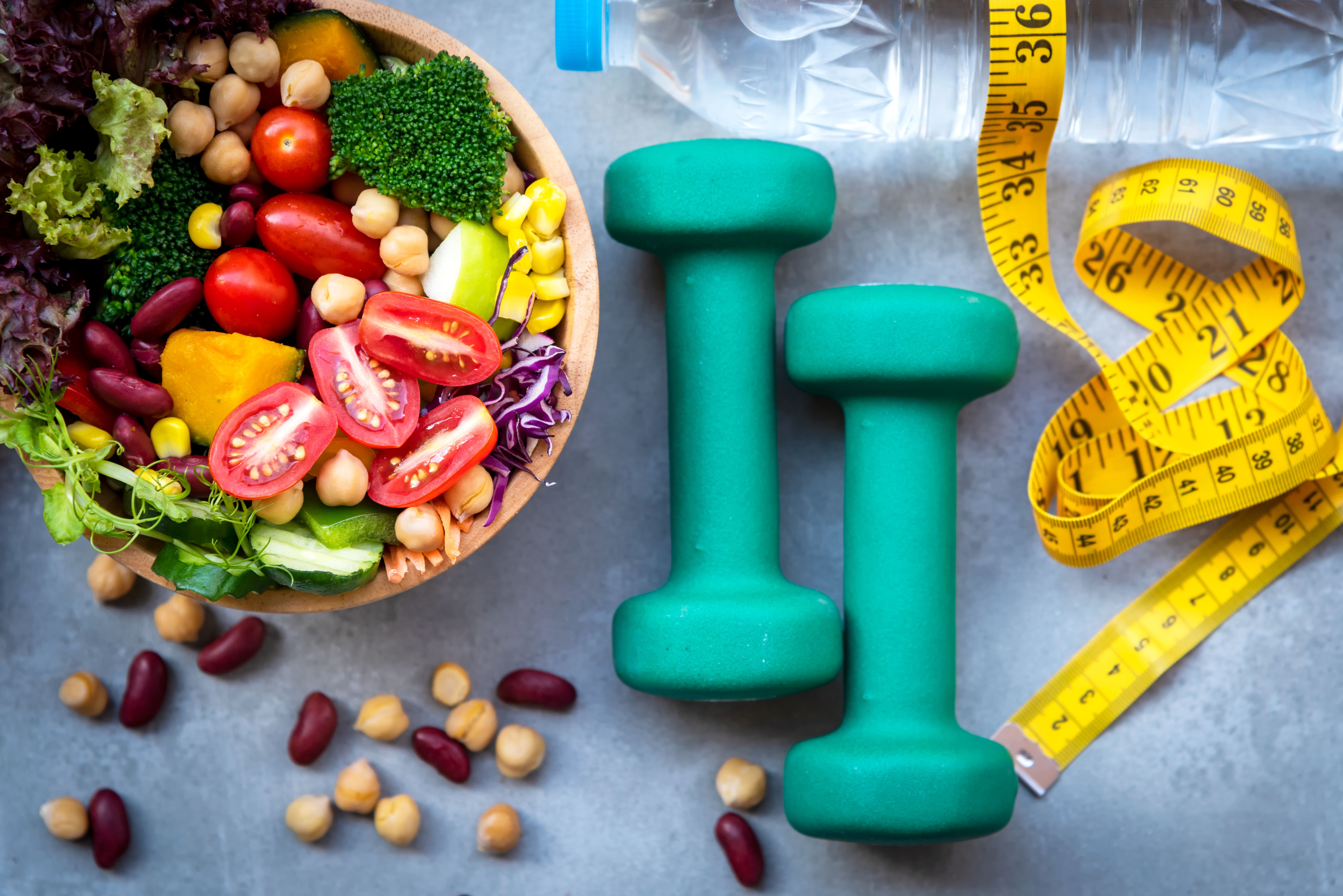 Fresh vegetable salad and healthy food for sport equipment for women diet slimming with measure tap for weight loss on wood background. Healthy Sport Concept - Image credit: Freebird7977 | stock.adobe.com
