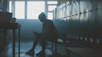 Caucasian female athlete preparing for a workout in a gym locker room, putting on earphones and choosing music on her phone