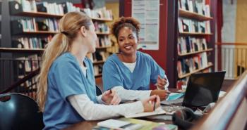 Two pharmacy students in a library -- Image credit: peopleimages.com | stock.adobe.com