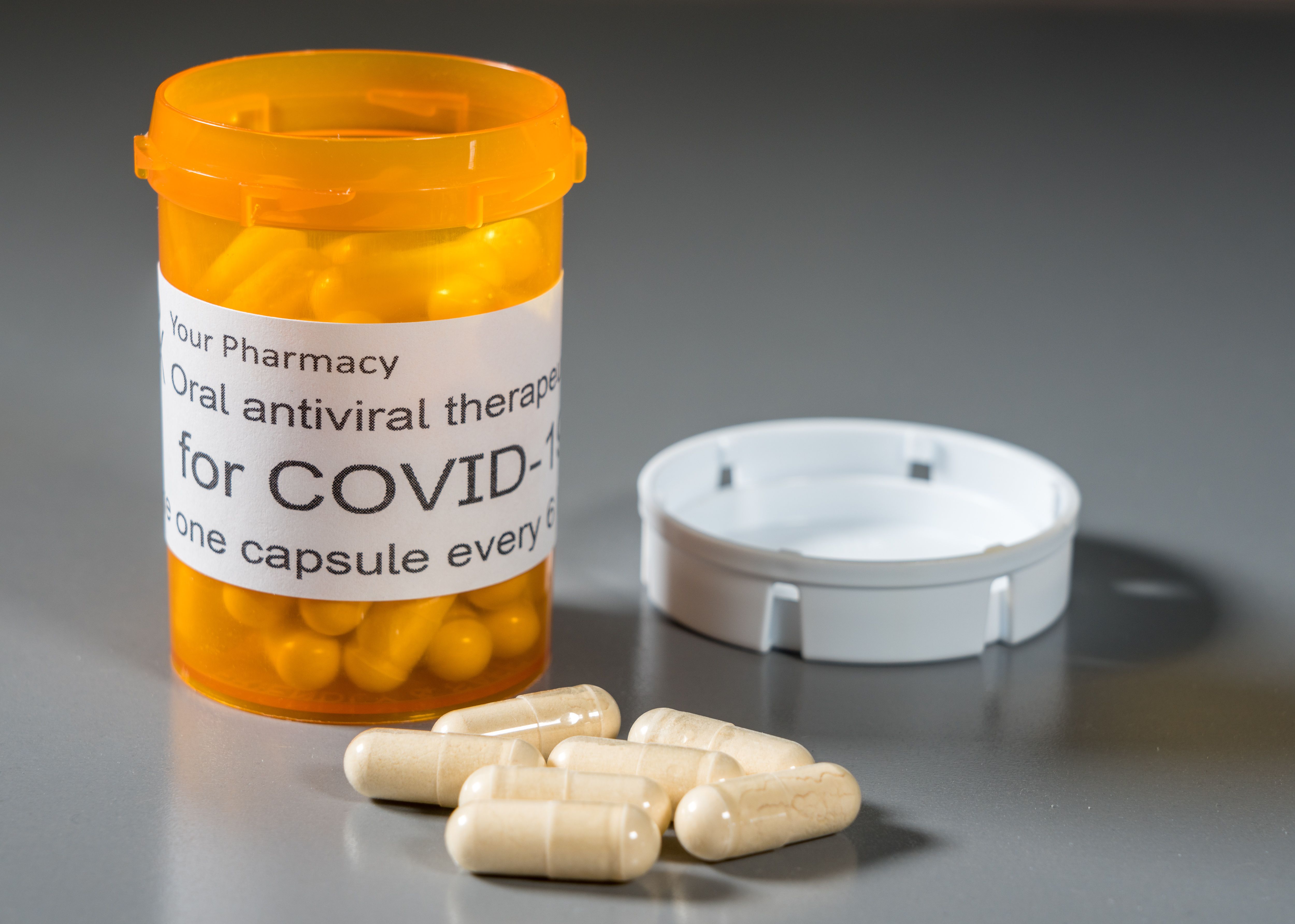 Prescription bottle and capsules illustrating trials of oral antiviral treatment for SARS-CoV-2 or Covid-19 virus - Image credit: steheap | stock.adobe.com