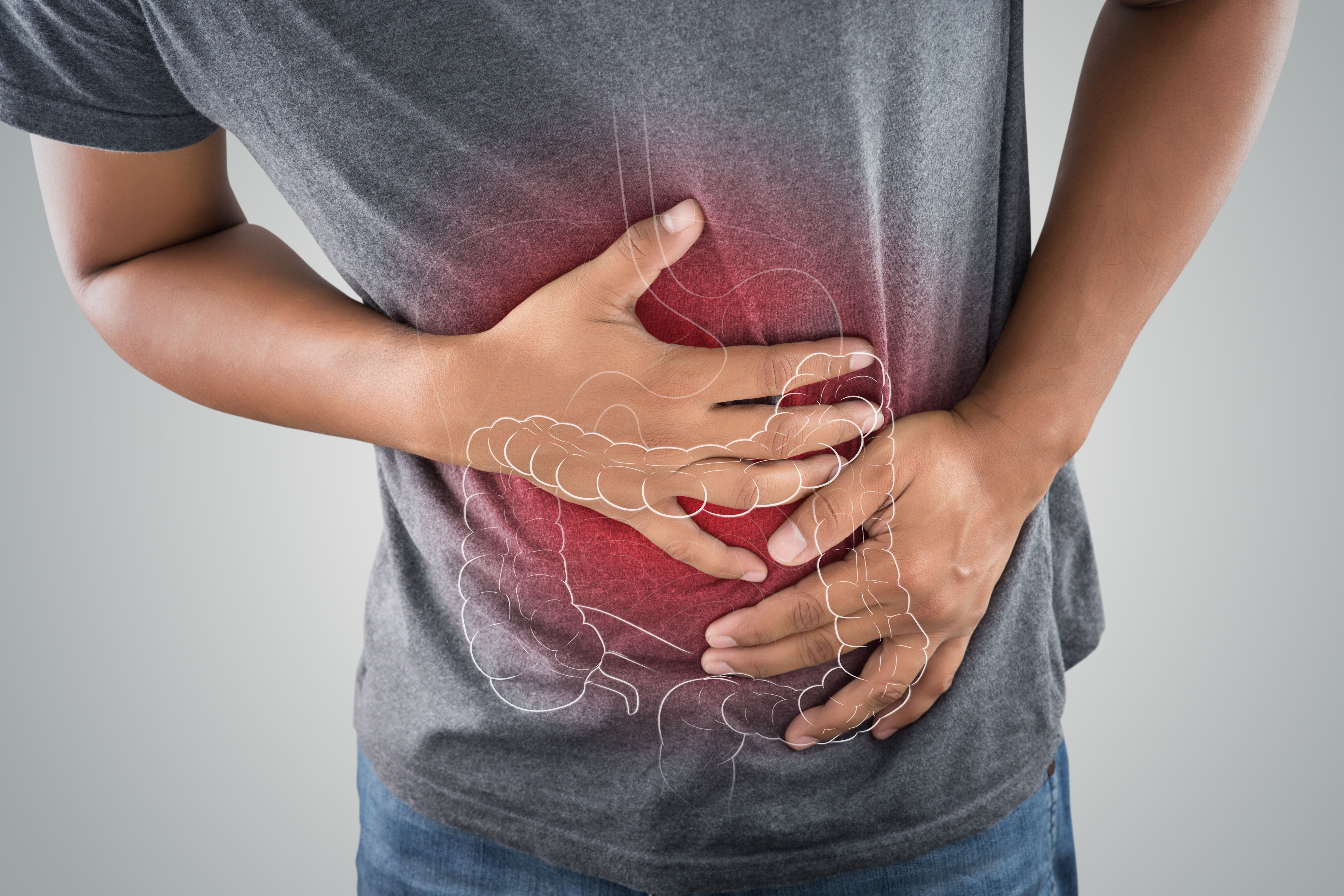 The photo of large intestine is on the man's body against gray background, People With Stomach ache problem concept, Male anatomy | Image credit: eddows | stock.adobe.com