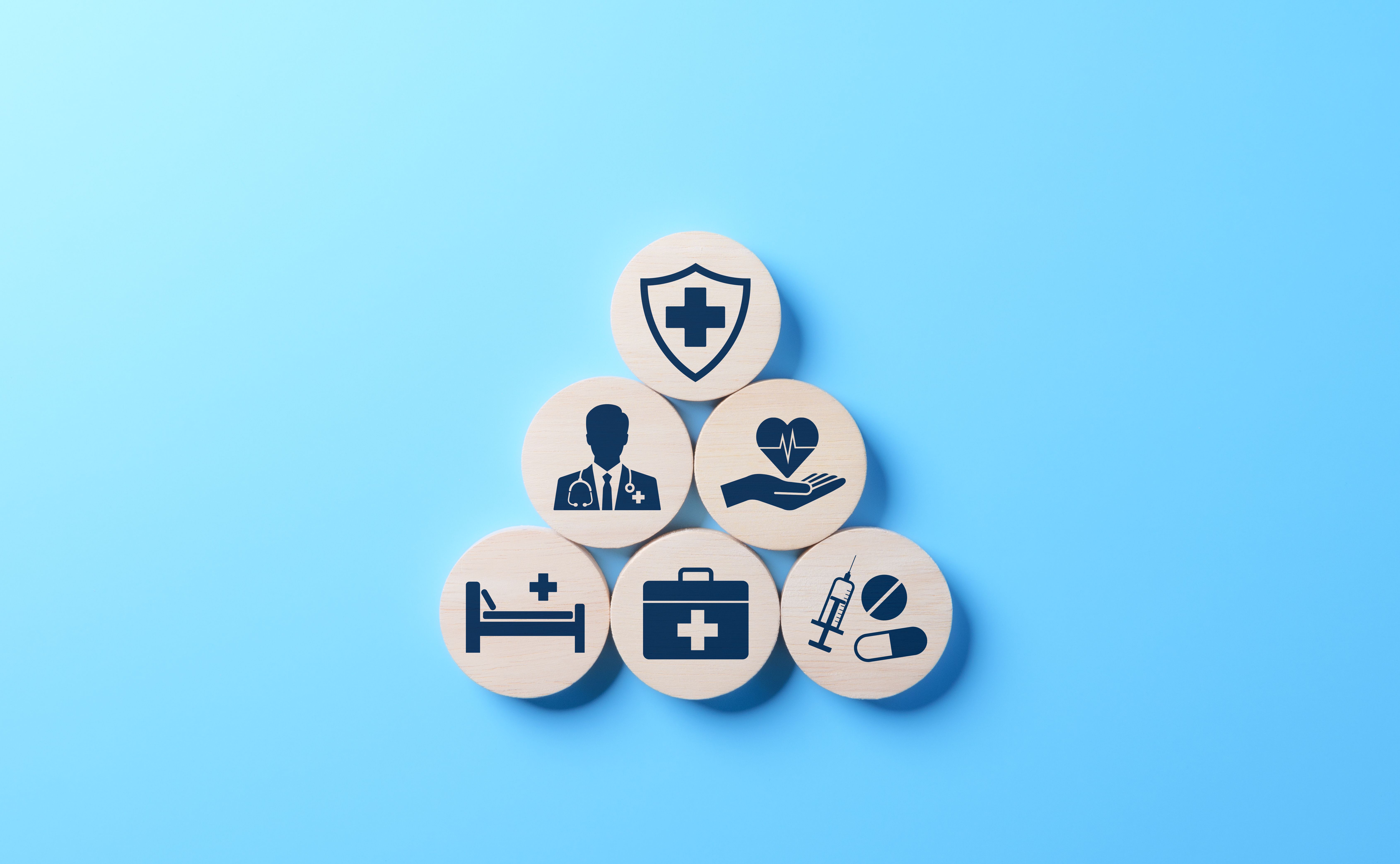 Health insurance and medical care concept. A set of wooden blocks displaying health-related icons, medical care, health insurance, and medication. healthcare services, protection, insurance coverage - Image credit: Supatman | stock.adobe.com 