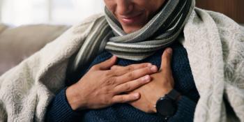Hands, chest pain and sick on sofa with blanket for flu, rest and recovery in lounge at house. Person, respiratory illness and cold symptoms with congestion, comfort or healing in living room at home