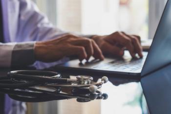 Male doctor in white coat typing on laptop computer keyboard with medical stethoscope on the desk in medical room at clinic or hospital. Online medical technology, emr, telehealth or meditech concept. | Image Credit: NIKCOA - stock.adobe.com