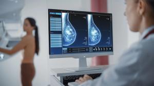 Computer Screen in Hospital Radiology Room: Woman Standing Undergoing Mammography Screening Procedure. Screen Showing the Mammogram Scans of Dense Breast Tissues - Image credit: Gorodenkoff | stock.adobe.com