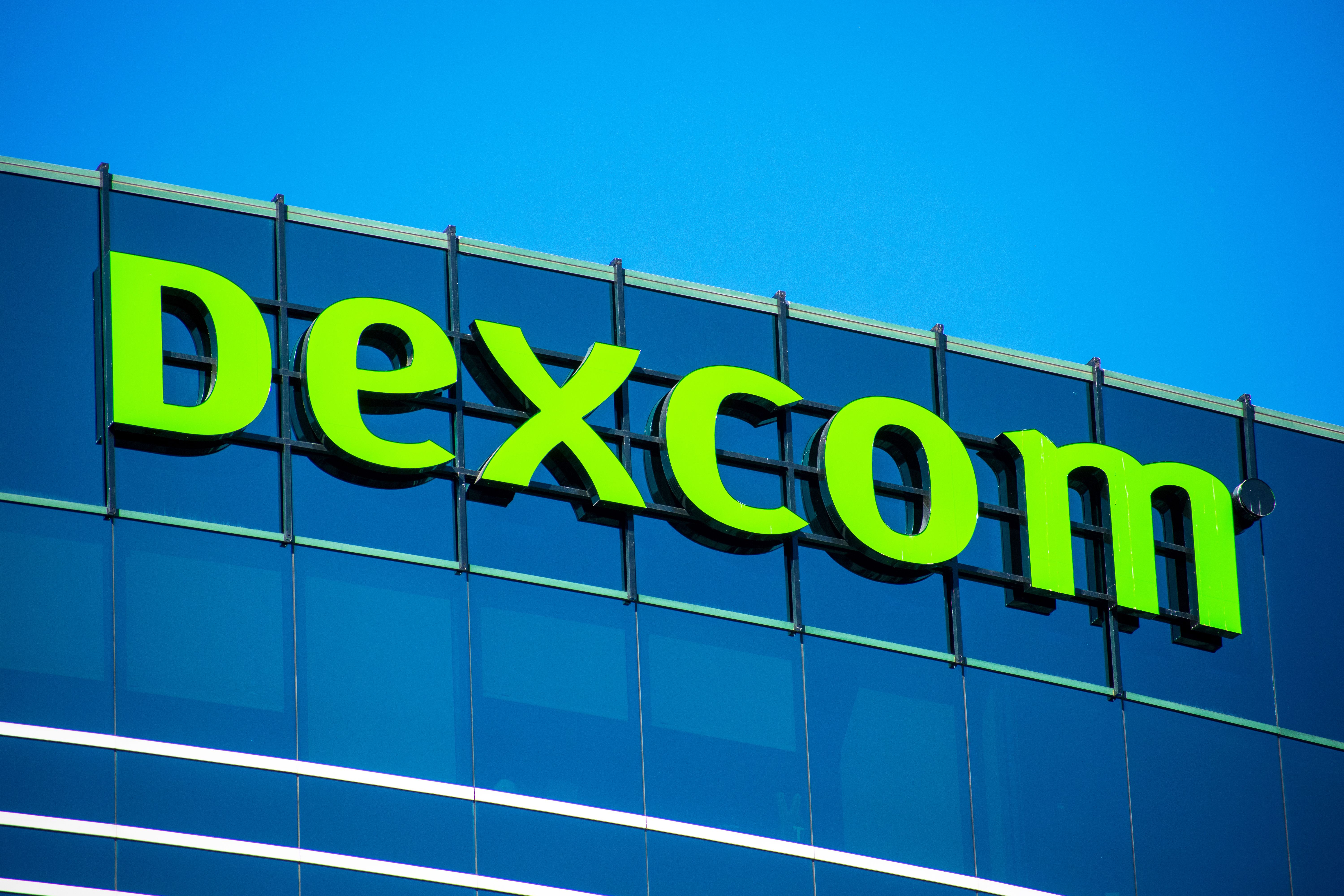 Dexcom logo sign atop headquarters campus. DexCom, Inc. develops, manufactures, and distributes glucose monitoring systems for diabetes management- San Diego, California, USA - 2020 - Image credit: MichaelVi | stock.adobe.com