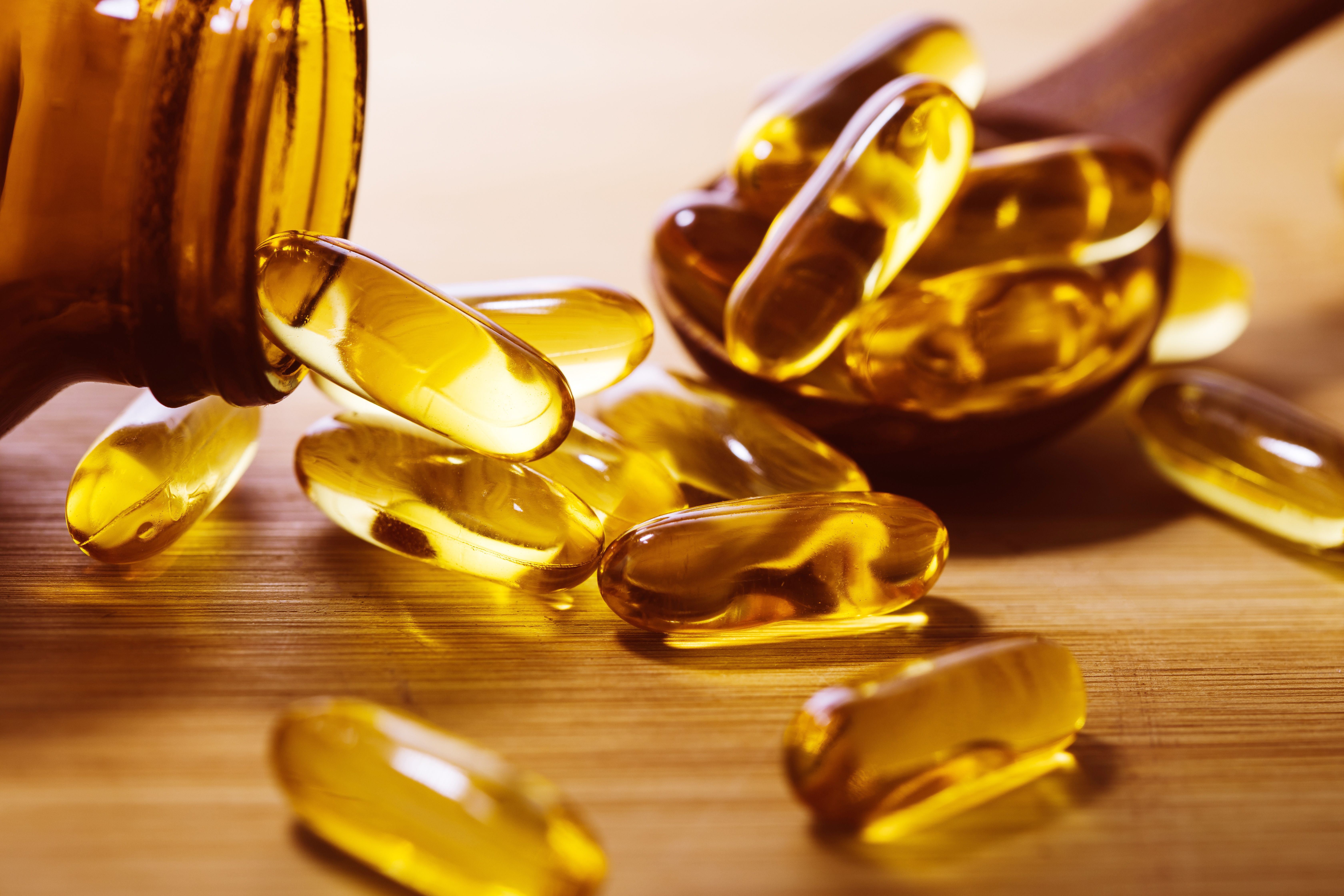 Close up the vitamin D and Omega 3 fish oil capsules supplement on wooden plate for good brain , heart and health eating benefit - Image credit: Cozine | stock.adobe.com 