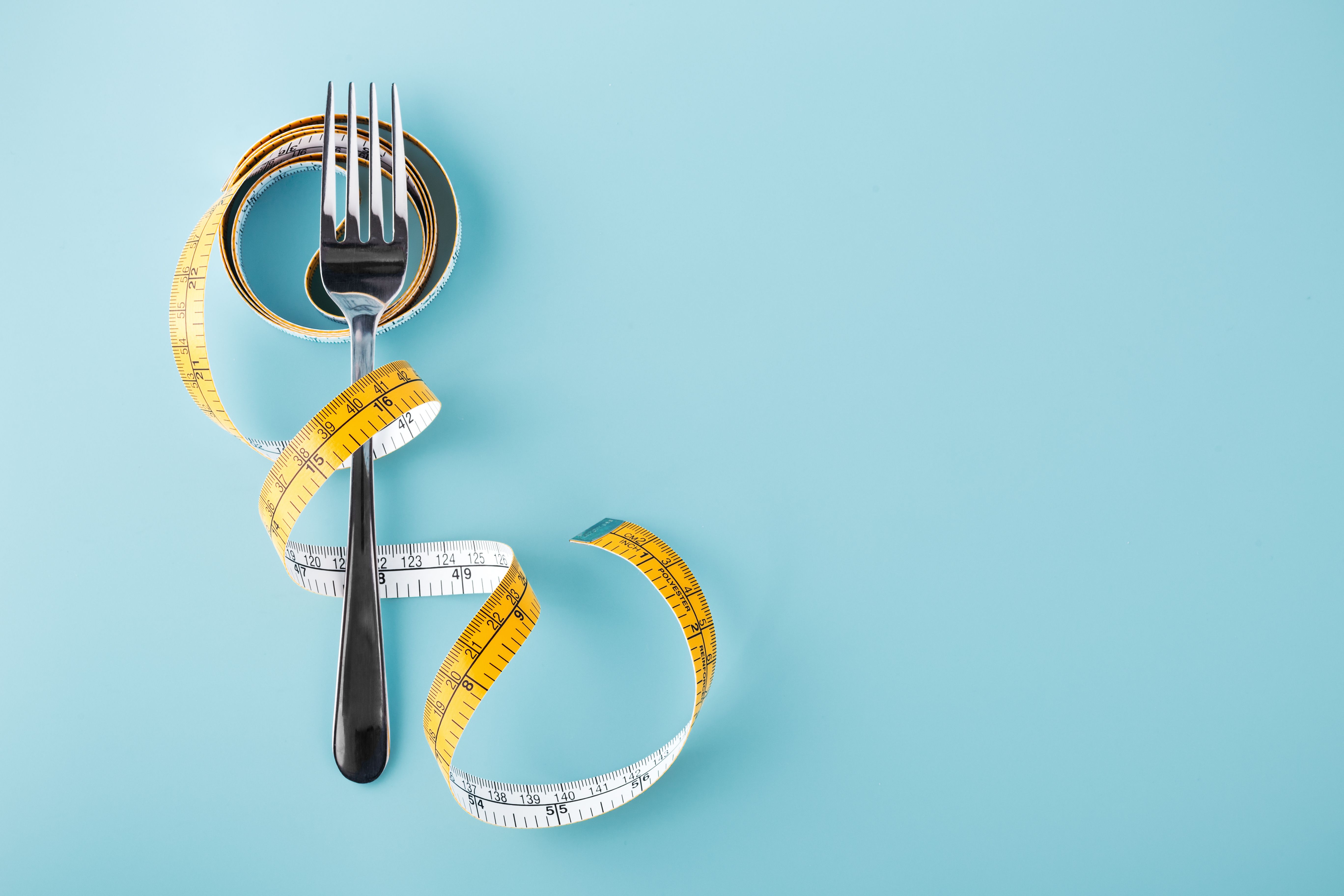 Fork with measuring tape around, diet background - Image credit: thanksforbuying | stock.adobe.com