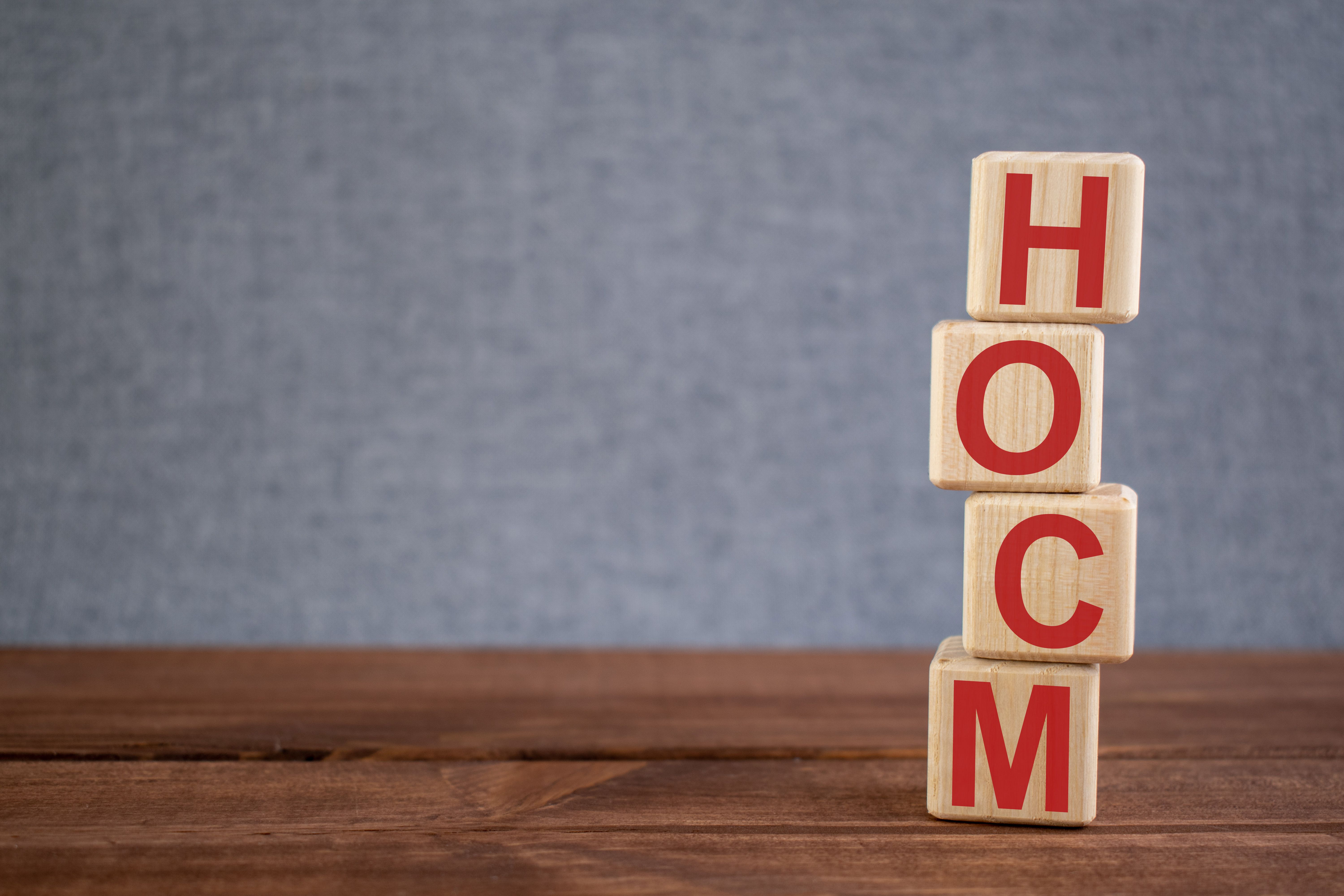 Abbreviation HOCM (hypertrophic obstructive cardiomyopathy) text acronym on wooden cubes on dark wooden backround. Medicine concept. | Image Credit: Anna | stock.adobe.com