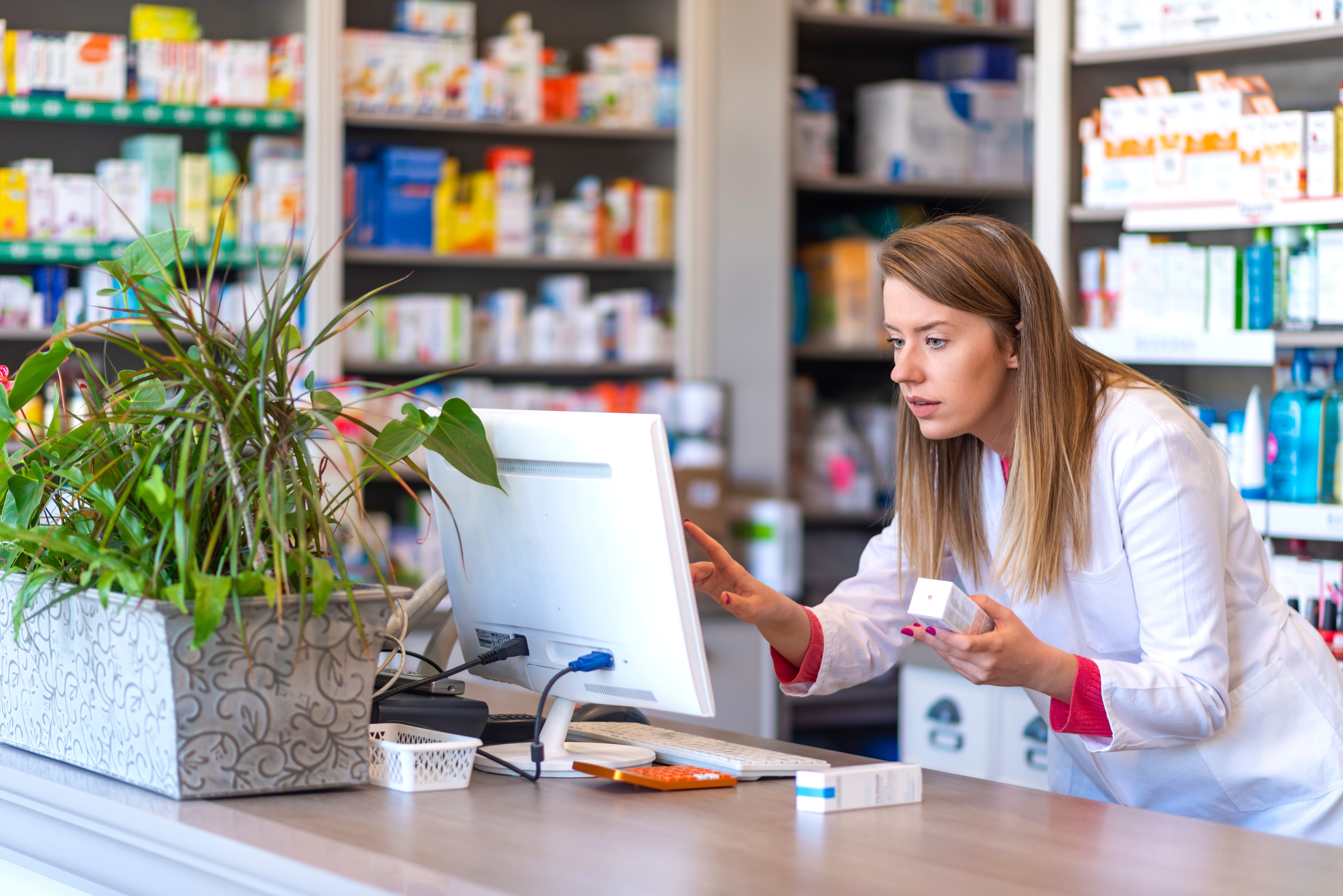 Pharmacist looking at records on computer