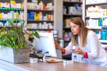 Pharmacist looking at records on computer