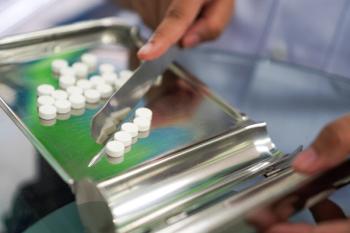 Pharmacy technician preparing or filling medication -- Image credit: Nattawat | stock.adobe.com