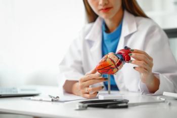 Health care provider with model of human heart -- Image credit: NanSan | stock.adobe.com