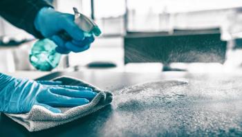 Cleaning home table sanitizing kitchen table surface with disinfectant spray bottle washing surfaces with towel and gloves. COVID-19 prevention sanitizing inside. | Image Credit: Maridav - stock.adobe.com