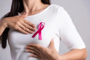 Woman with breast cancer awareness pink ribbon on her shirt -- Image credit: Siam | stock.adobe.com
