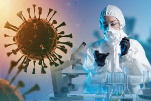 Doctor of Infectious Diseases. Scientist studies infection bacteria. Virus near doctor in chemical protection suit. Woman infectious disease specialist in respirator. Microscope and flasks on table | Image Credit: Grispb | stock.adobe.com