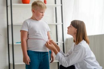 Little chubby boy being measured by a friendly doctor.