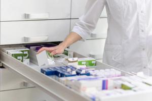 Pharmacist holding medicine box and capsule pack in pharmacy drugstore. | Image credit: Aliaksandr | stock.adobe.com