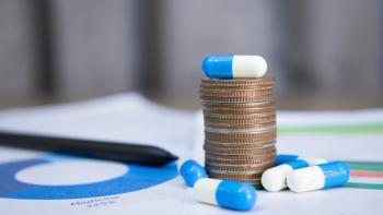 Blue and white capsules on and around a stack of coins, meaning health insurance, medical expenses and medicine, finance, saving money, business, financial and medical healthcare concepts.