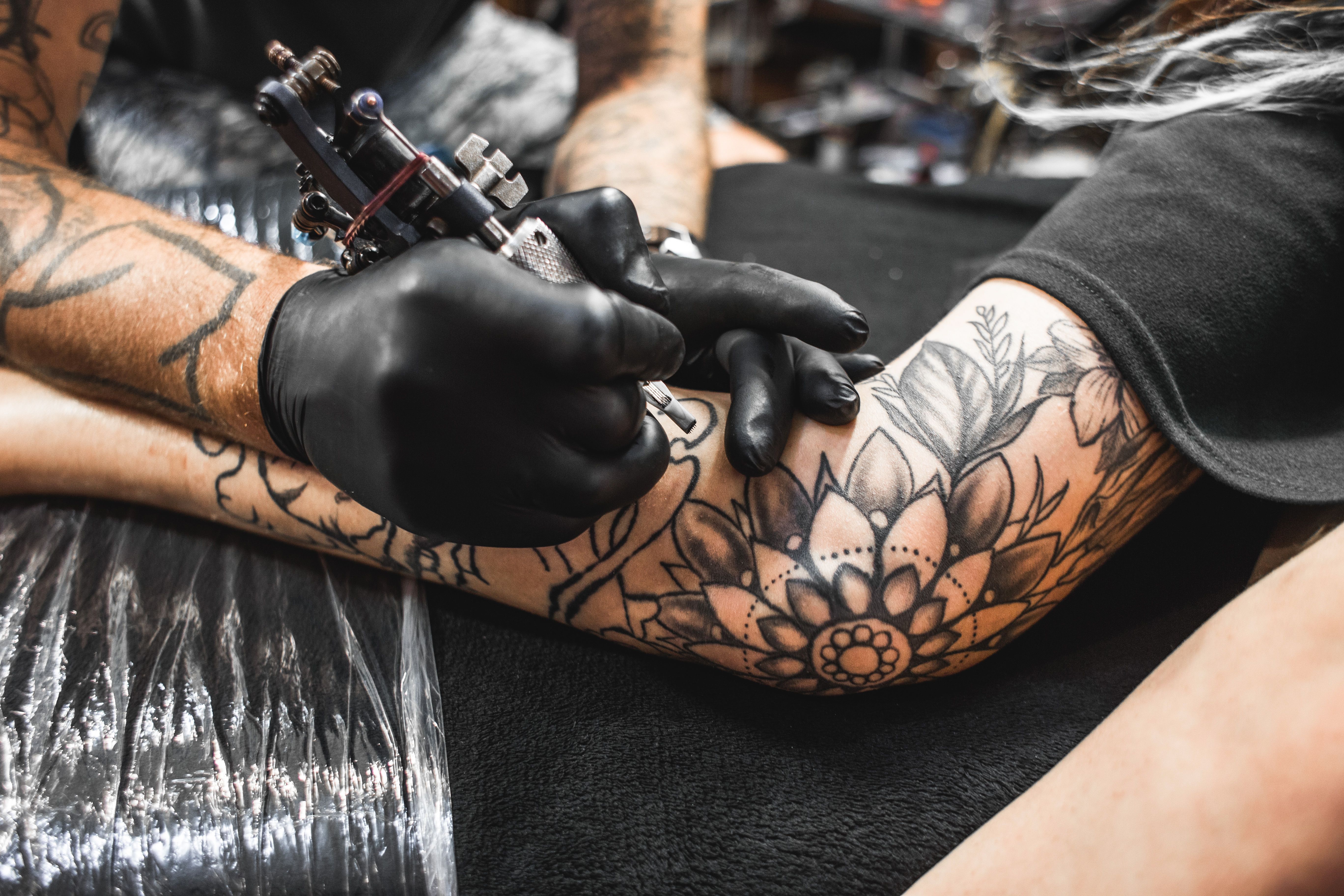 Close up of a person receiving a tattoo on their arm.