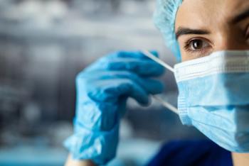 Health care professional putting on a face mask -- Image credit: RomanR | stock.adobe.com