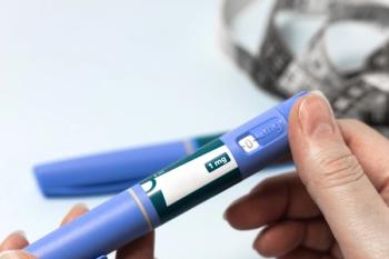 Hand holding Ozempic injection pen for diabetes treatment.