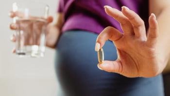 pregnant woman drinks pills. Pregnant woman holding a glass of water and vitamins for pregnant women in her hands, focus on the hand. Pregnancy health concept  - Image credit: ProstoSvet | stock.adobe.com