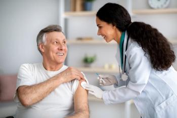 Millennial doctor making medical drug injection or anti-covid vaccine to disabled senior man in wheelchair at home