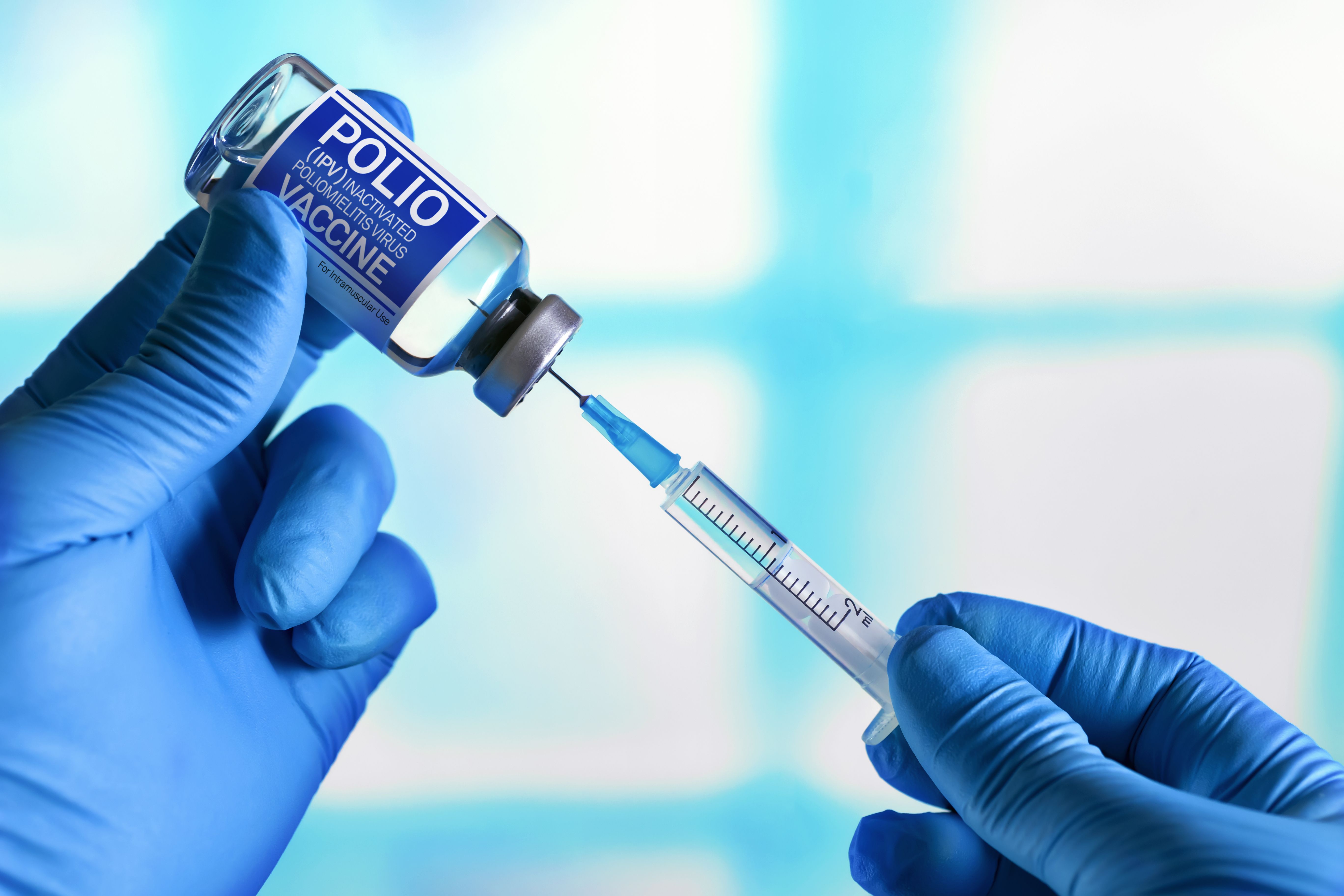 Doctor with vial of the doses vaccine and syringe for Polio IPV Inactivated poliomyelitis Virus. Vaccination and health care concept. Vaccination for booster shot for Polio IPV Inactivated poliomyelit - Image credit: angellodeco | stock.adobe.com