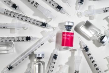 Close up of Retatrutide Vial with Red Label and Single Use Insulin Syringes Gauge 31 with Other Clear Glass Vials