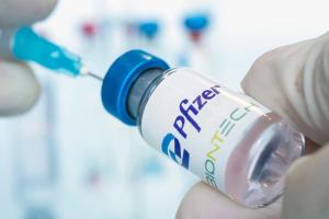 Vials of liquid the logos pfizer and biontech in the doctor's hand