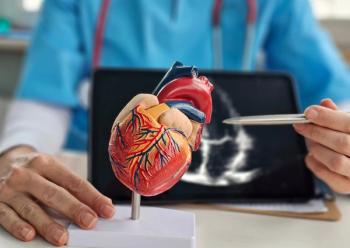 Pharmacist with a model depicting a heart -- Image credit: Nadzeya | stock.adobe.com