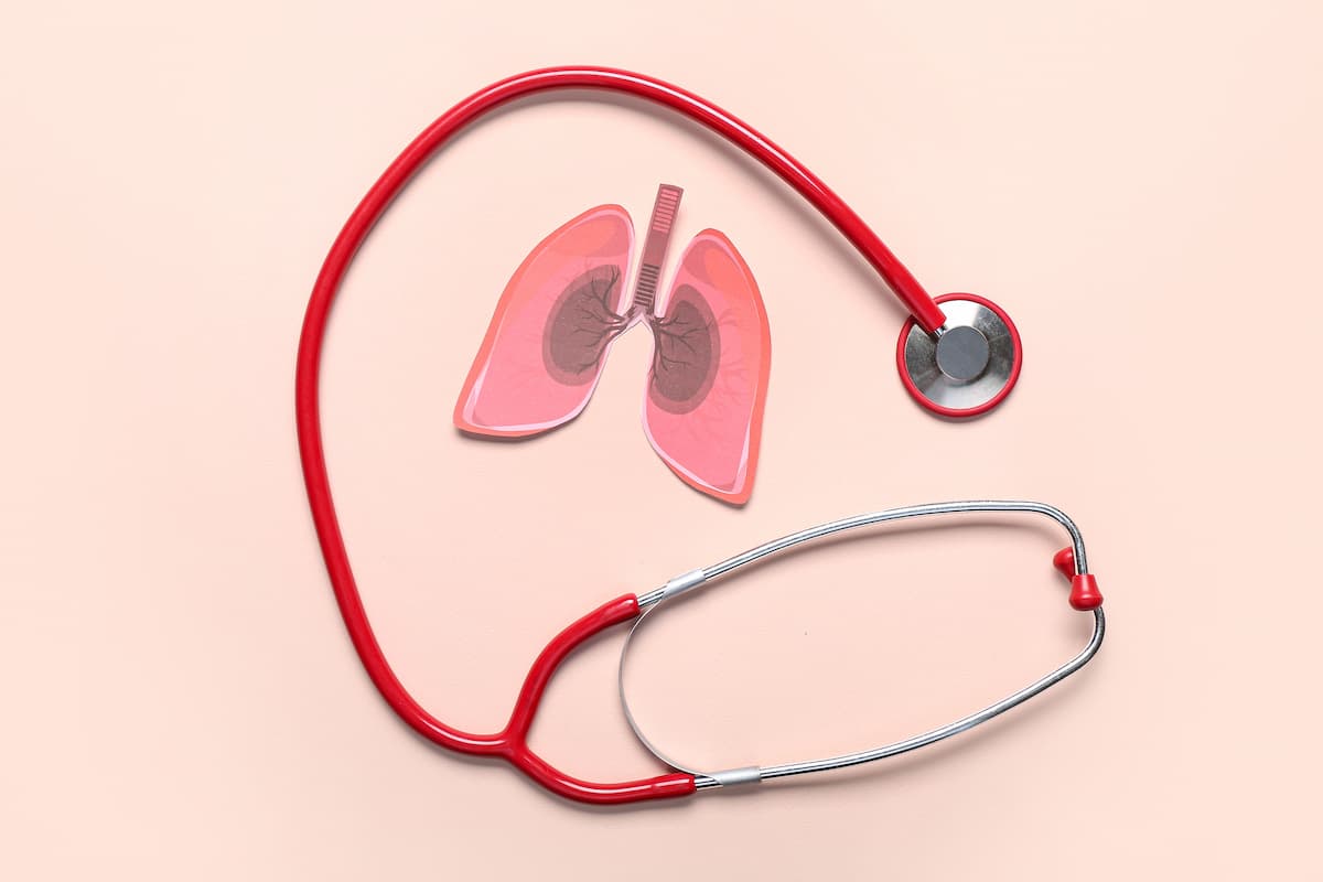 Paper lungs and stethoscope on beige background