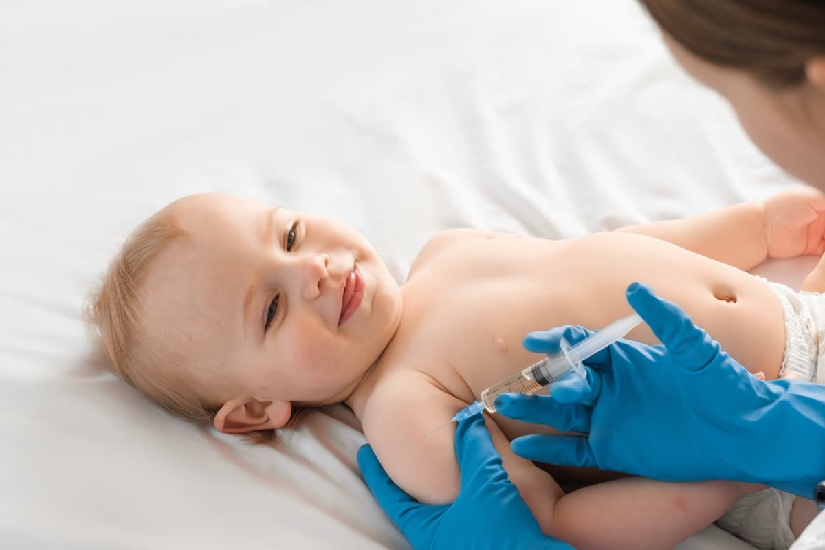 Doctor vaccinating baby in clinic. Little baby get an injection. Pediatrician vaccinating newborn baby. Vaccine for infant child.